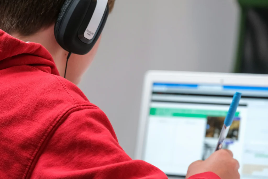 Seorang anak sedang belajar online di depan laptop.