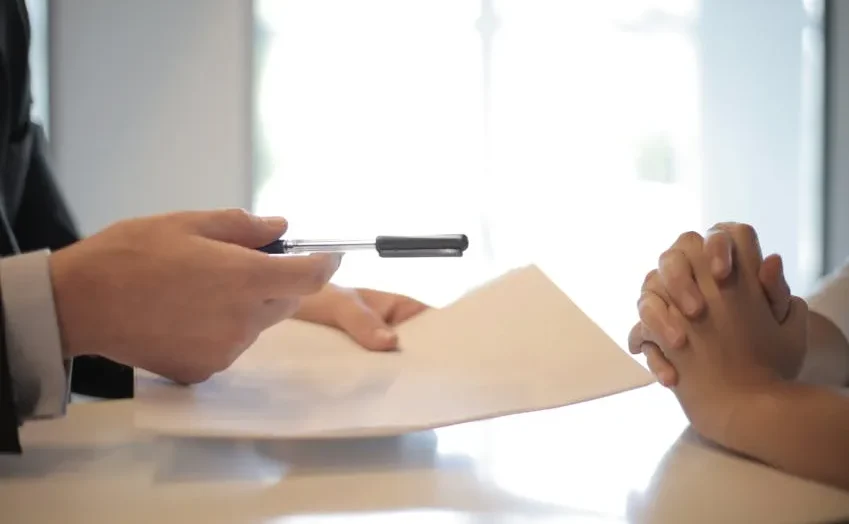 Seseorang sedang menandatangani dokumen penting.